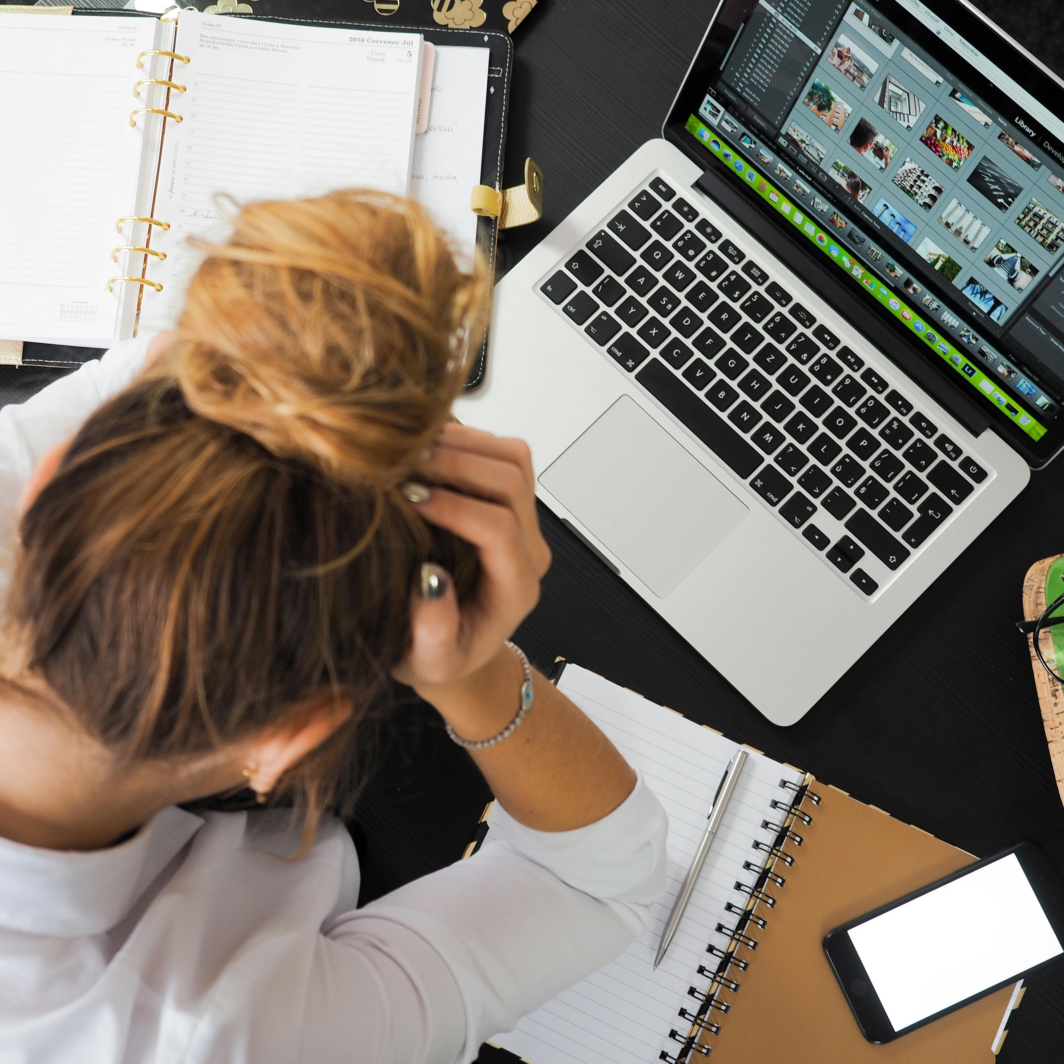 image of a person leaning on a desk next to a briefcase surrounded by money.